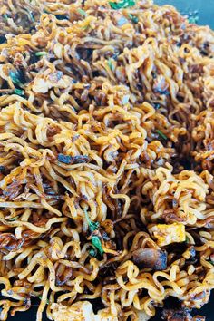 noodles with meat and vegetables on a black plate