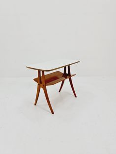 a wooden table with a glass top and two shelves on each side, against a white background