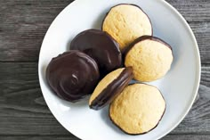 three chocolate covered cookies on a white plate