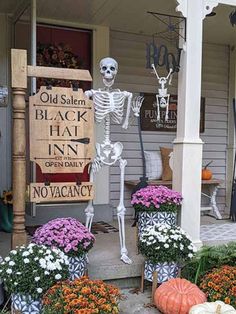 a porch decorated for halloween with pumpkins and flowers