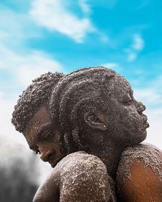 two black people covered in snow against a blue sky