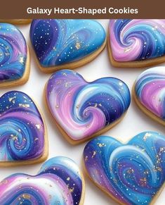 some heart shaped cookies are decorated with blue and purple swirled icing