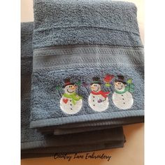 three towels with embroidered snowmen on them