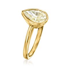 a yellow gold ring with a pear shaped diamond