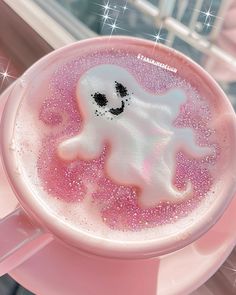 there is a pink drink with white sprinkles and a ghost face on it