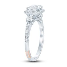 a white gold engagement ring with two diamonds on the band and an oval shaped center stone