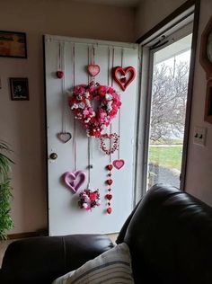 a door decorated with pink and red heart garlands hanging from it's side