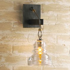 a light that is on the side of a brick wall with a lamp attached to it