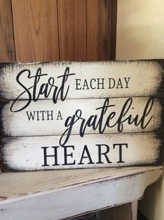 a wooden sign that says start each day with a grateful heart on the front and side