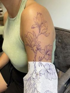 a woman with a flower tattoo on her arm