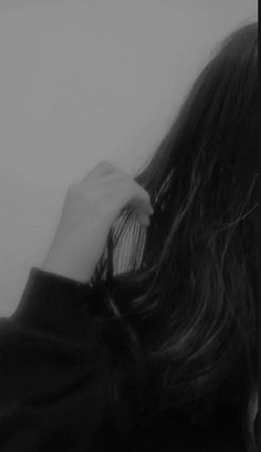 black and white photograph of a woman brushing her long hair with an electric toothbrush