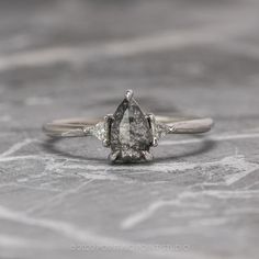 an engagement ring with a pear shaped diamond