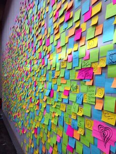 a wall covered in post it notes with hearts and other writing on the walls next to each other