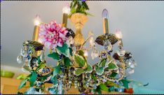 a chandelier with candles and flowers on it