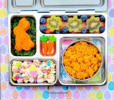 a bento box filled with different types of food and fruit on top of it