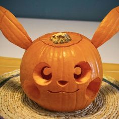 an orange pumpkin with ears and eyes carved into it