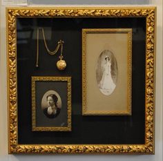 two framed pictures are hanging on the wall next to a necklace and an old - fashioned photo