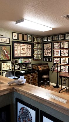 a room filled with lots of framed pictures on the wall and wooden counter top next to it