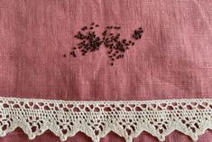 an embroidered piece of cloth with crochet on the edge and small holes in it