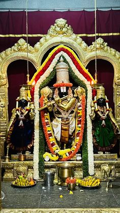 the statue is decorated with flowers and garlands on it's head, surrounded by other decorations