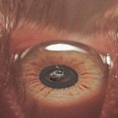 an eye looking through the iris of someone's eye with a ring on it