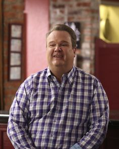 a man sitting at a bar with his hands in his pockets and looking to the side