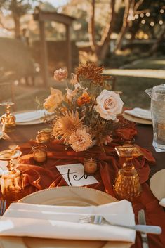 the table is set with flowers and place settings for an elegant dinner party or celebration