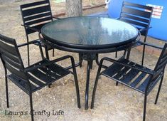 an outdoor table and four chairs sitting on the ground