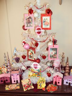 a white christmas tree decorated with pictures and ornaments