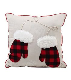 a white pillow with red and black mittens on it