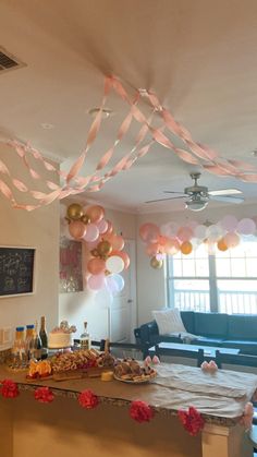 a party with balloons and confetti hanging from the ceiling