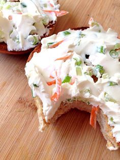 two pieces of bread with white frosting and veggies on them