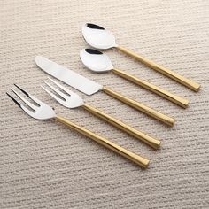 four forks, two spoons and one knife are laid out on the floor next to each other