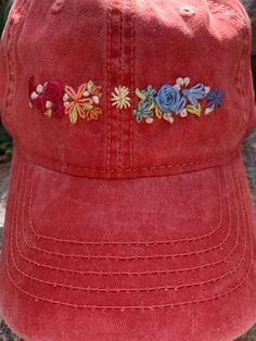 a red hat with embroidered flowers on it