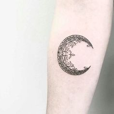 a black and white photo of a crescent tattoo on the right forearm, with an intricate design