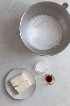 ingredients to make cheesecake sitting on a counter top next to a saucepan and spoon