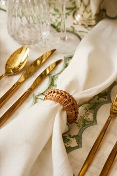 a table topped with gold colored utensils and napkins