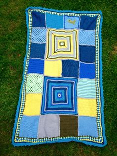 a blue and yellow blanket laying on the grass