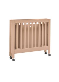 a baby crib with wheels on the bottom and sides, in light brown color