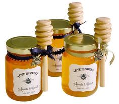 honey jars with labels on them sitting on a white tablecloth and the words love is sweet written below