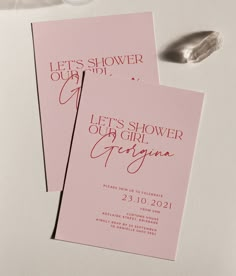 two pink cards with red lettering on them sitting next to a spoon and some candy