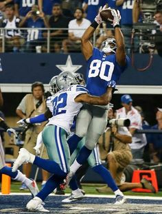 two football players are jumping up in the air