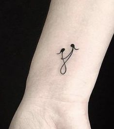 a small black and white tattoo on the wrist