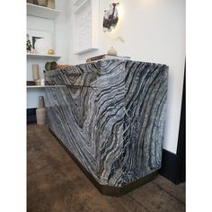 a marble counter top sitting in the middle of a room next to a white wall