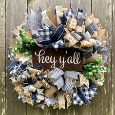 a wreath with the words hey y'all on it hanging on a wooden fence