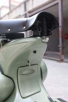 an old green scooter parked on the street