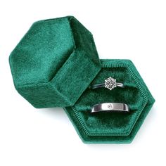 two wedding rings sitting in a green velvet ring box