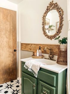 a bathroom with green cabinets and a white sink