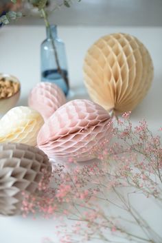 three honeycombs are sitting on a table next to some flowers and vases