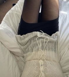 a woman laying in bed with her legs crossed